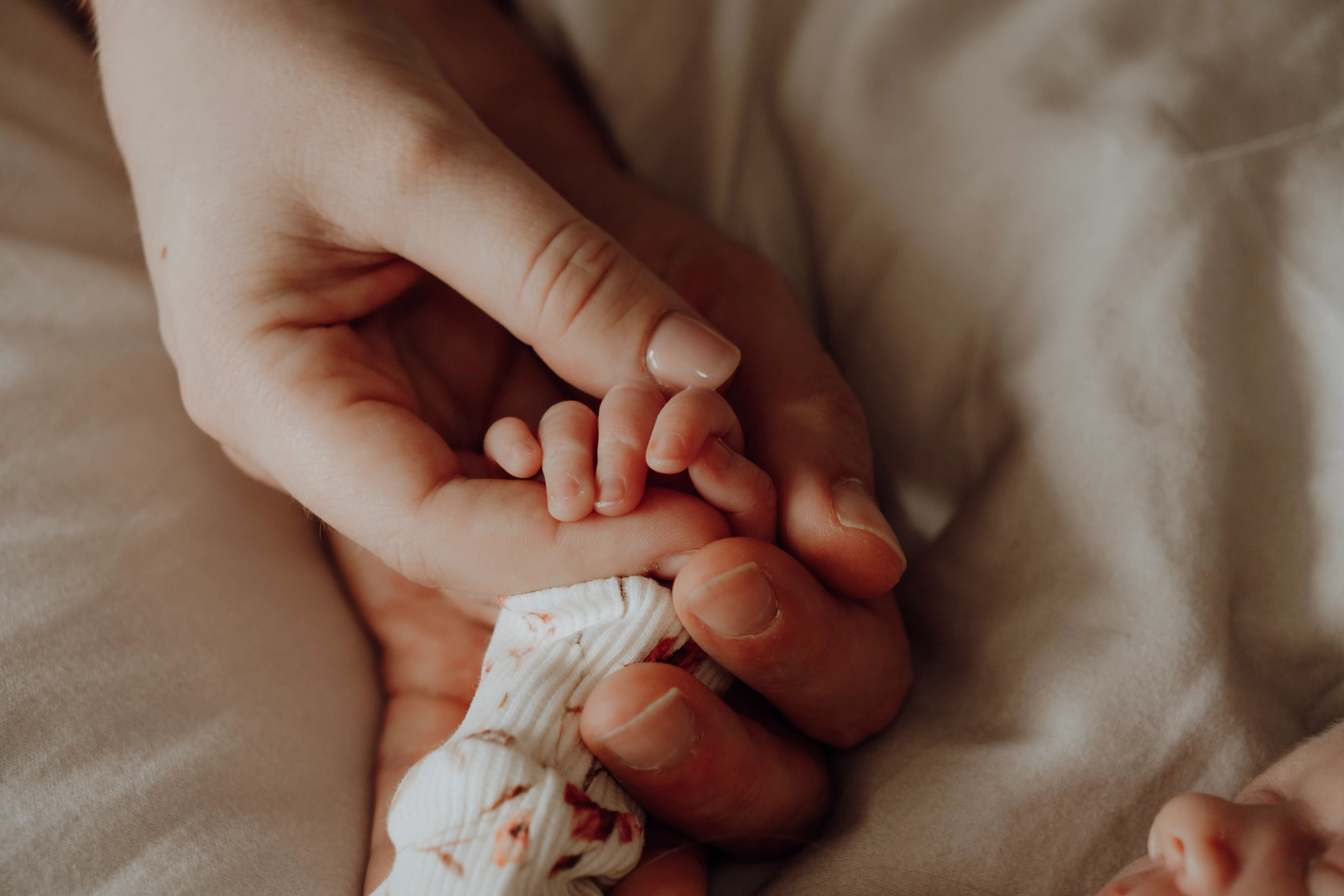 Pasgeboren baby rustig vastgelegd in een warme newbornshoot aan huis