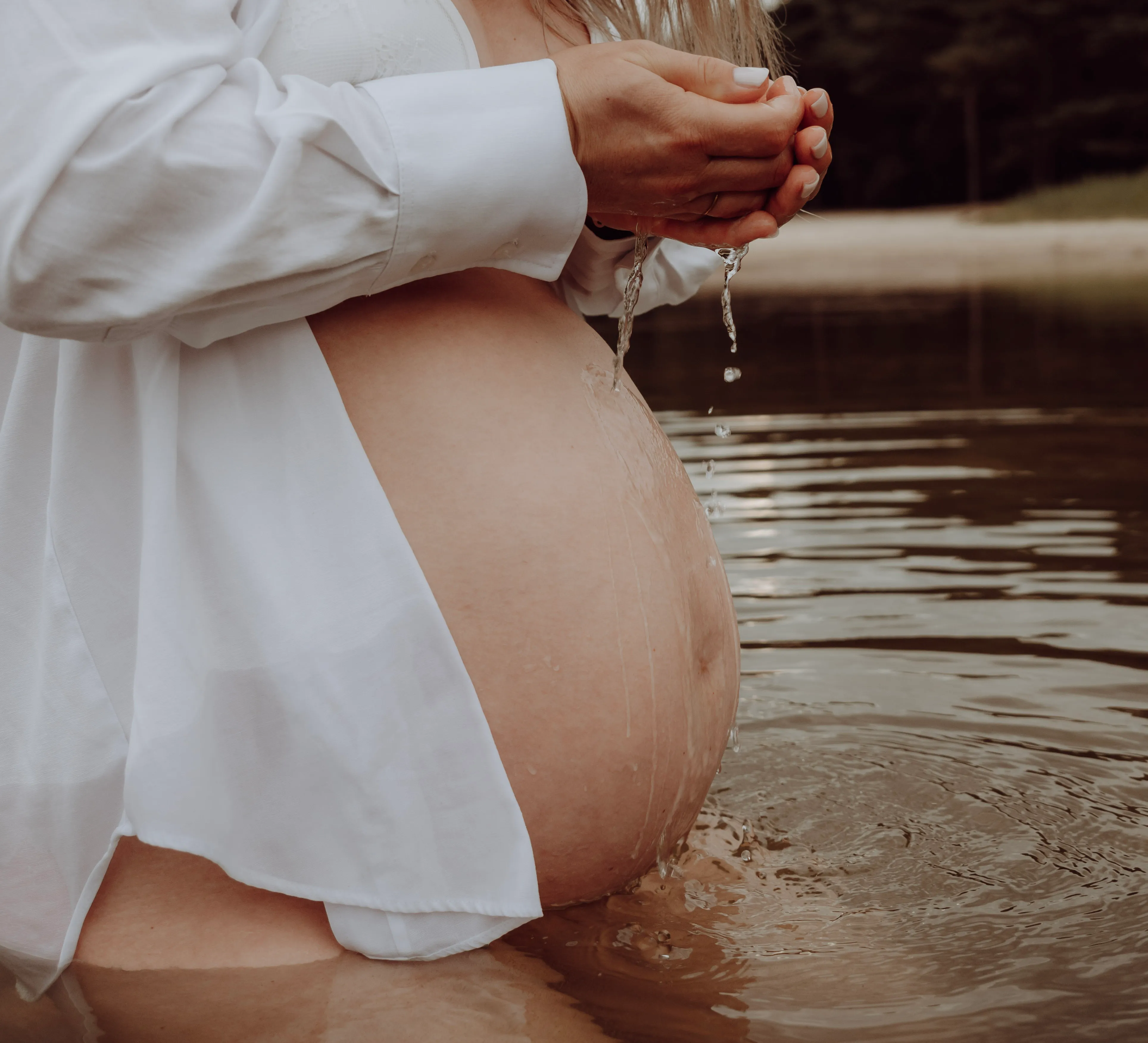 Zwangere vrouw tijdens een warme zwangerschapsshoot in natuurlijk licht
