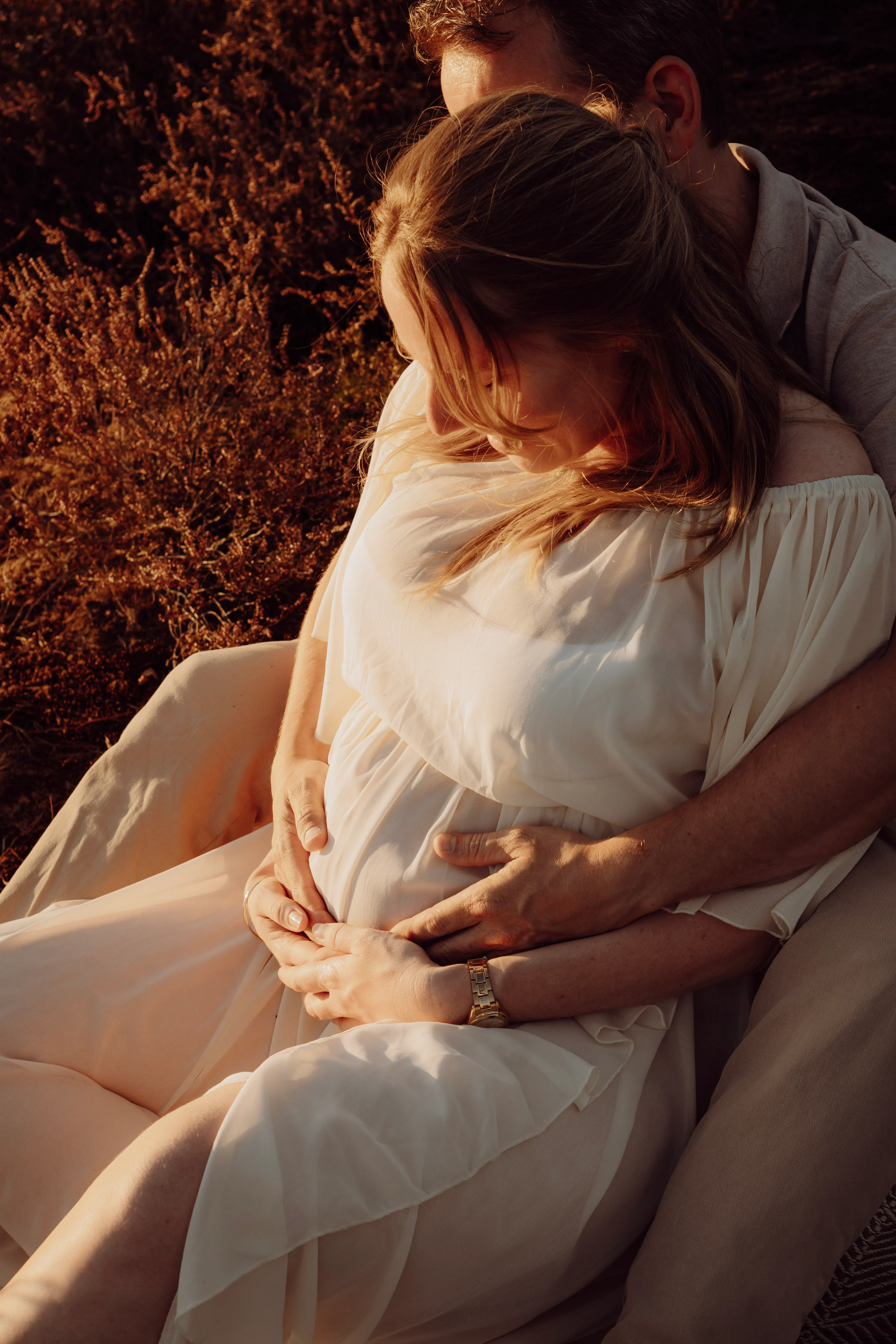 Zwangere vrouw buiten in de natuur tijdens golden hour
