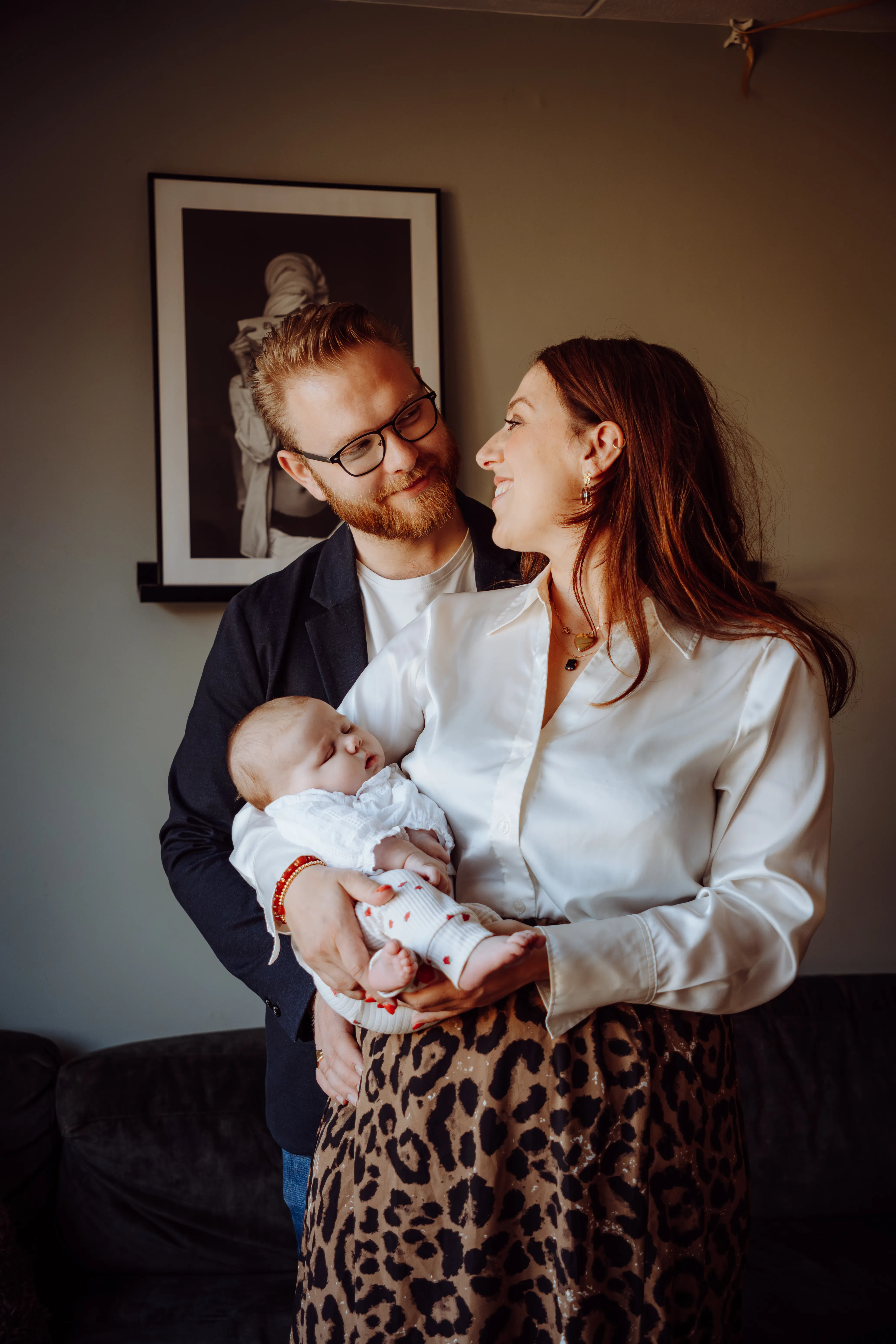Ouders wiegen hun pasgeboren baby in de woonkamer thuis