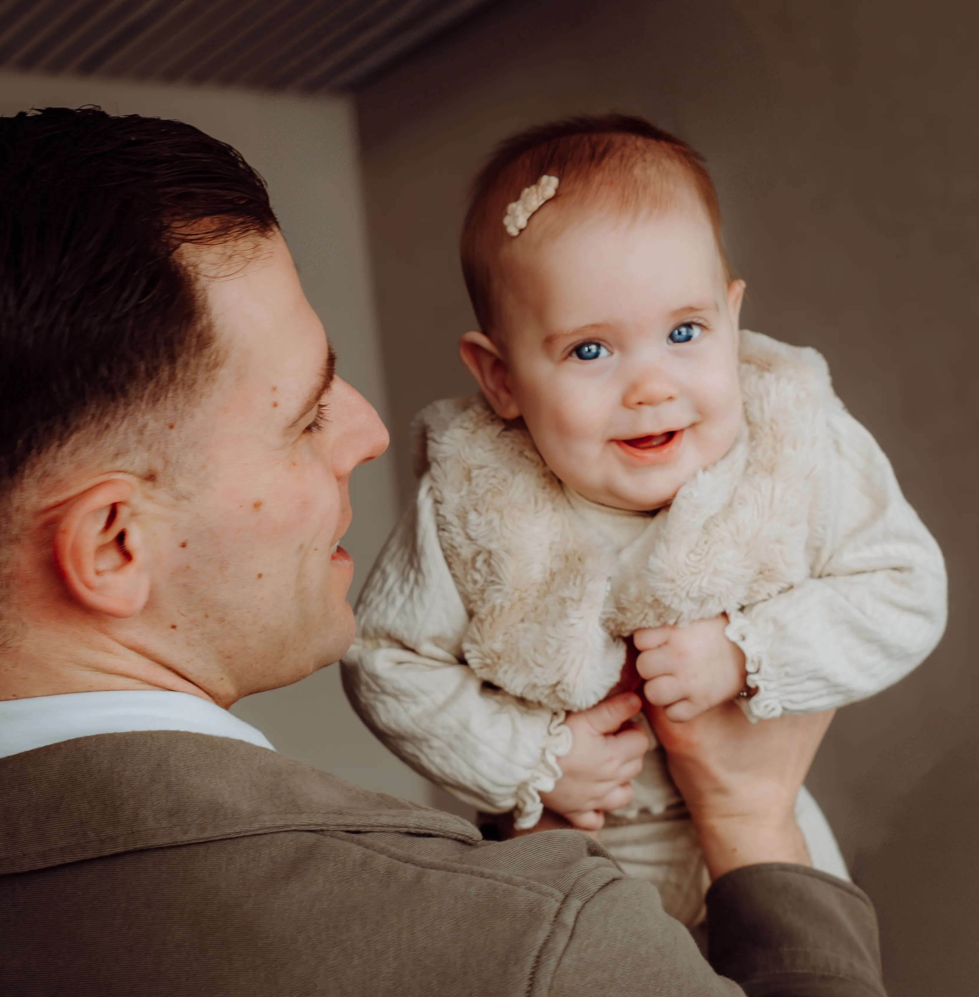 Lief moment tussen ouder en lachende baby tijdens een thuisshoot