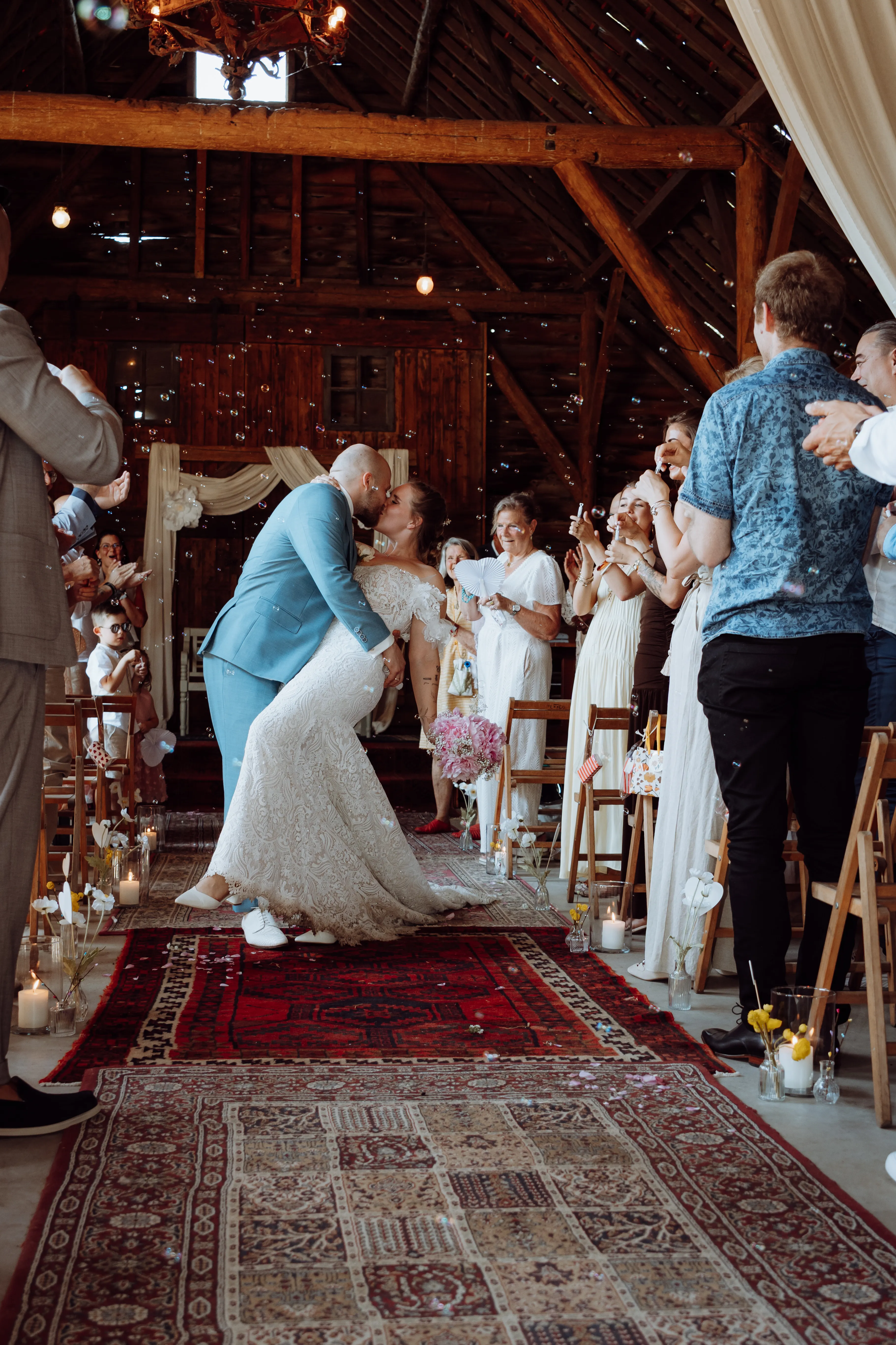 Het bruidspaar geeft elkaar een kus tijdens de ceremonie in de schuur